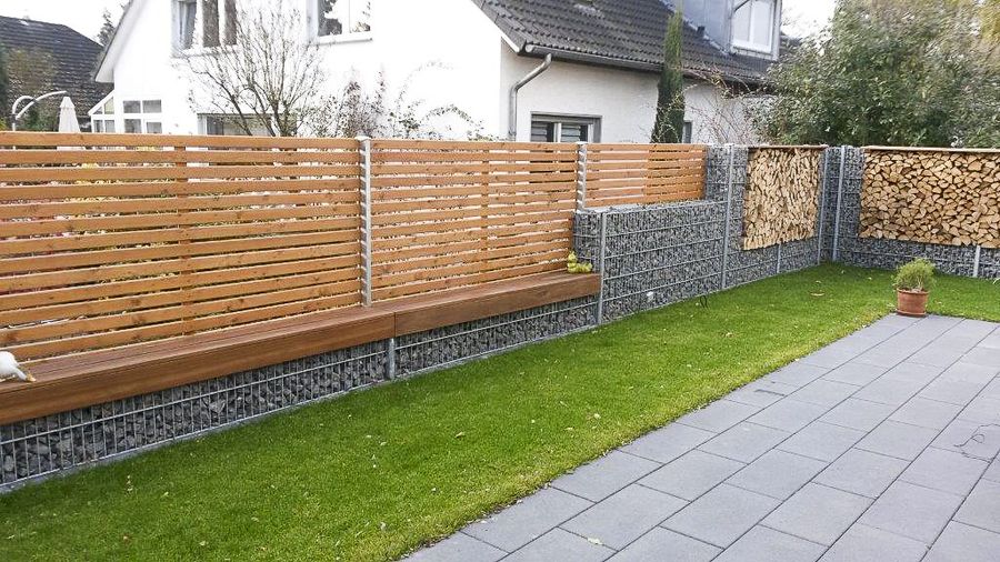 Gabionenwand mit Holzzaun und Rasenfläche