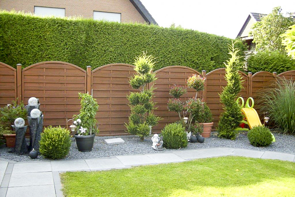 Neu bepflanzte Gartenkante entlang eines Holzzauns